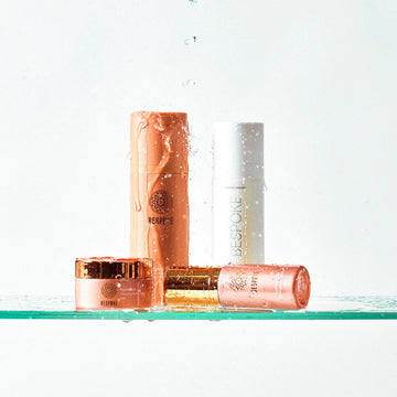 Skincare products on a glass shelf with a white background